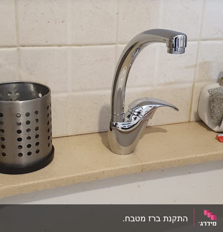 ברז כרום מעל כיור עם רשת ניקוז